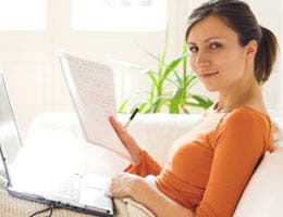 Woman working on laptop and paperwork