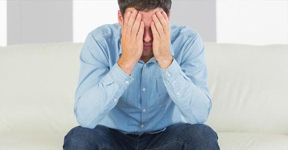Stressed man sitting with head in his hands © iStock