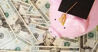 Piggy bank with grad cap on money © zimmytws/Shutterstock.com