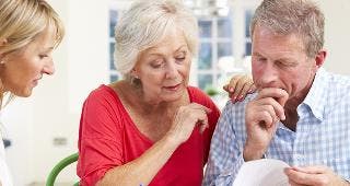 Older couple looking over document with adviser © Monkey Business Images/Shutterstock.com