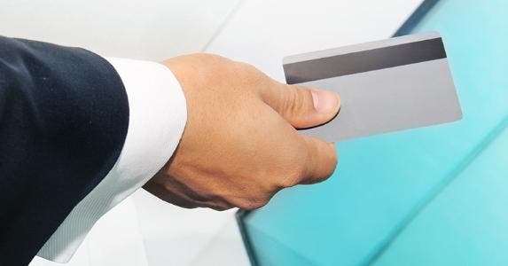 Business man holding silver card © Lucy Liu/Shutterstock.com