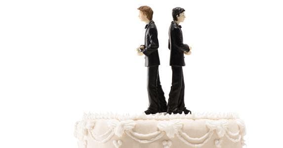 Two grooms on wedding cake, facing away from each other © iStock