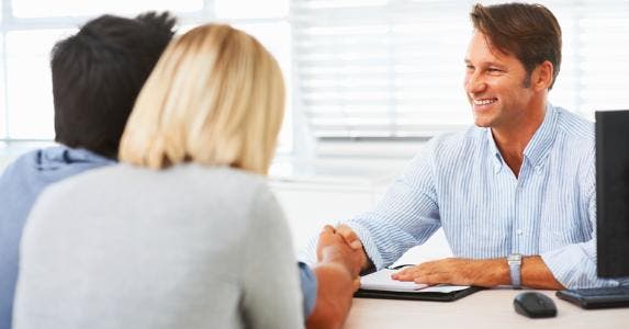 Adviser with couple, at his desk