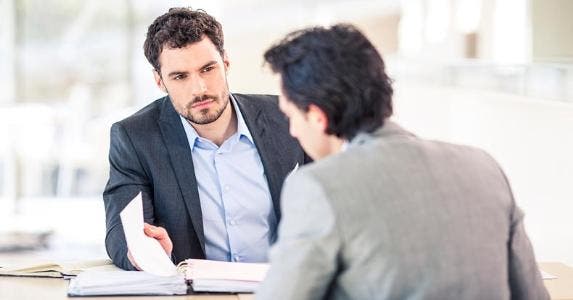 Can you expect a pay increase in 2016? Boss and employee sitting at table, reviewing binder | iStock.com