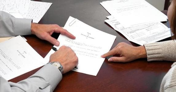 Land a good deal when buying a houseboat Adviser reviewing document with client | iStock.com/Jodi Jacobson