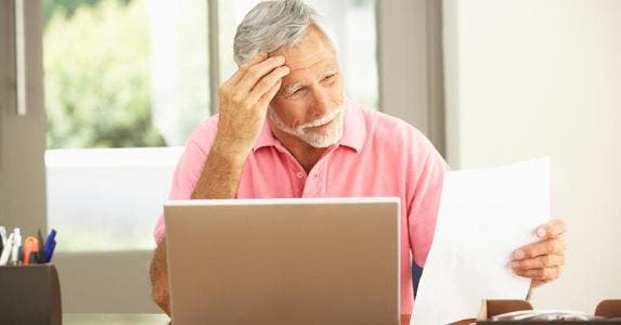 How long can that bad debt hang over me? Man grimacing at paper in his hand © iStock