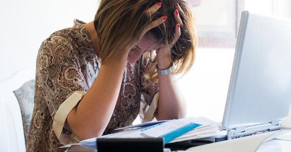 Stressed woman at her desk © iStock