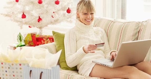5 warning signs of too much holiday credit card debt Woman doing holiday shopping from living room | Gazimal/Getty Images