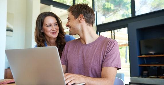 Happy couple browsing laptop computer © iStock
