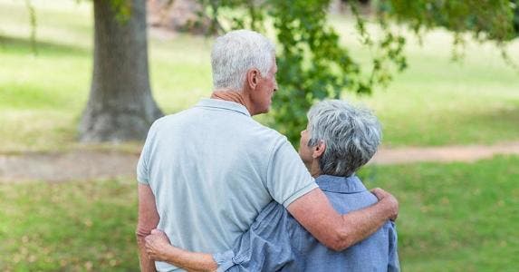 When should I claim spousal retirement benefits? Senior couple embracing at a park © iStock