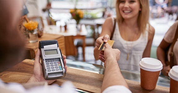 Woman handing credit card to cashier