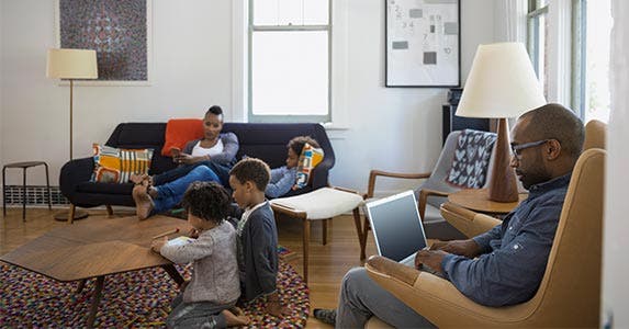 Husband and wife sitting in living room with three kids