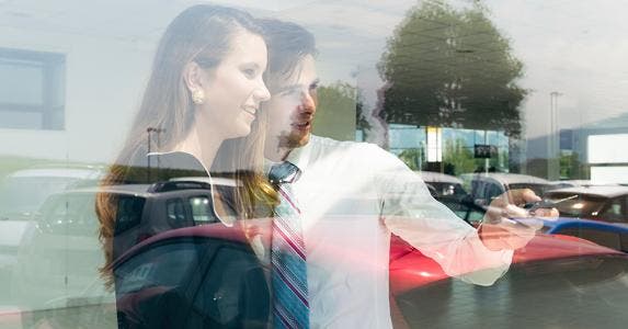 Salesman showing car from window © iStock