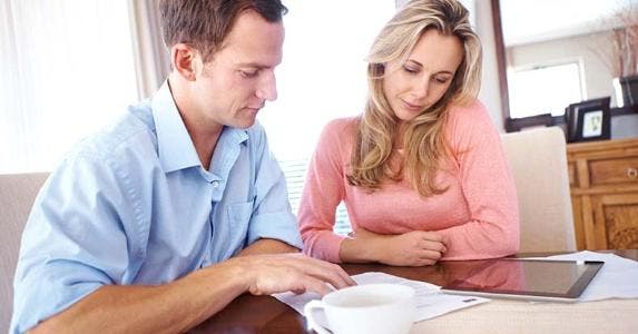 Survey: Rising interest rates are a widespread worry Couple going over papework and tablet computer on kitchen table | iStock.com/shapecharge