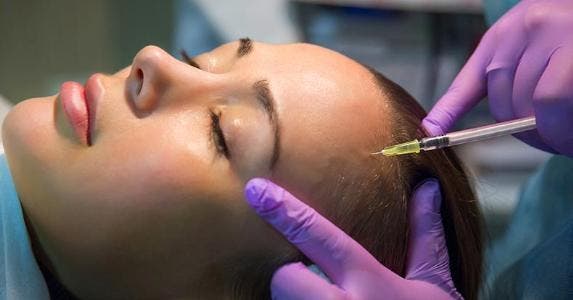How much does Botox cost? Woman getting botox shot on forehead © Anna Moskvina/Shutterstock.com