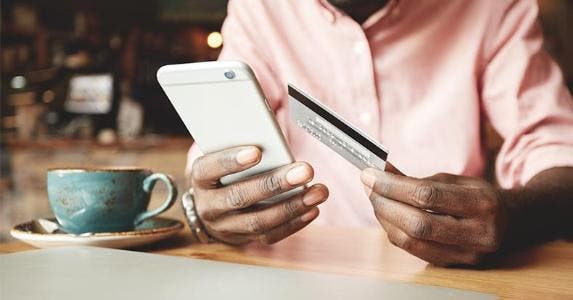 New card accounts rise to near pre-recession levels Man putting card numbers into his phone | WAYHOME studio/Shutterstock.com