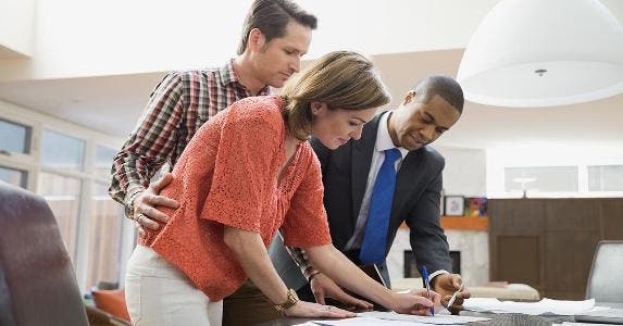 Couple signing closing forms for house | Hero Images/Getty Images