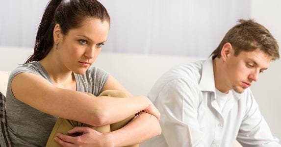 Sad couple sitting on couch © CandyBox Images/Shutterstock.com