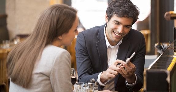 Man showing woman something on phone © LDprod/Shutterstock.com