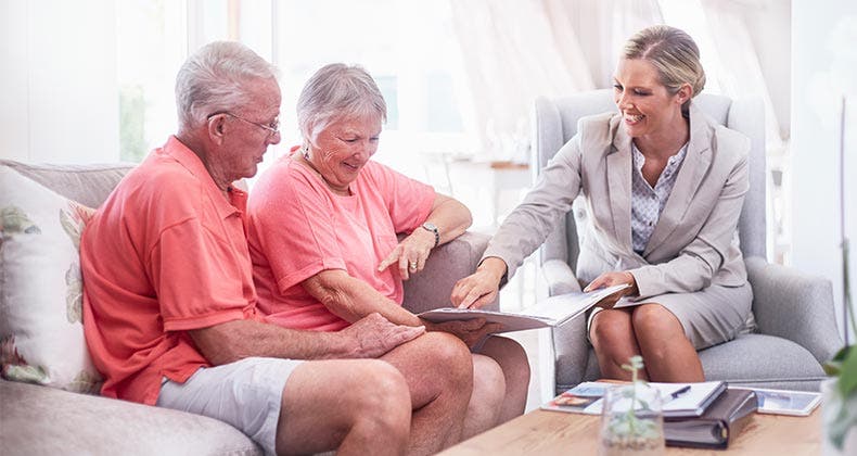 Passing the reverse mortgage assessment test Senior couple in coral shirts with adviser © Caiaimage/Trevor Adeline/Shutterstock.com