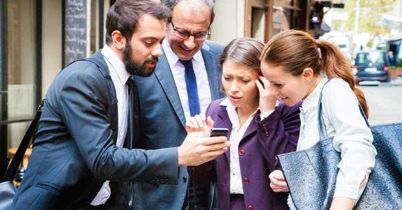 Man showing friends his phone's screen © iStock