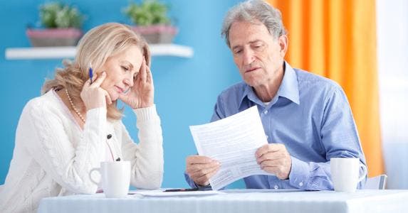 Senior couple looking over budget, bills © iStock