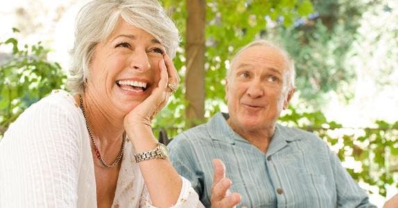 How do you get a reverse mortgage loan? Couple sitting outside, laughing at stories | Jim Purdum/Getty Images