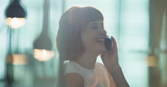 How to win a lower credit card rate: Ask Woman laughing while on the phone | Tom Merton/Caiaimage/Getty Images