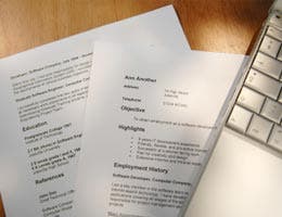 Resume with laptop on wooden table