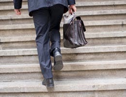 Man with briefcase climbing up the stairs