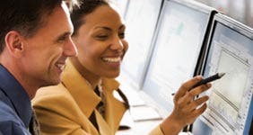 Man and woman looking at investing monitor