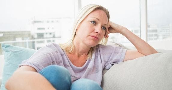 Sad woman, sitting on her couch © iStock