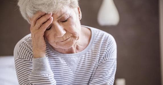 Do my debts pass on to my kids after death? Stressed senior woman wearing striped sweater | iStock.com/gpointstudio