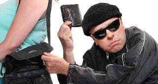 Thief stealing wallet from purse © Kletr/Shutterstock.com