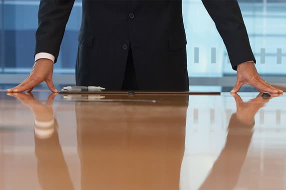 Hands on conference room table: © bikeriderlondon/Shutterstock.com; Money bag: maradonna 8888/Shutterstock.com