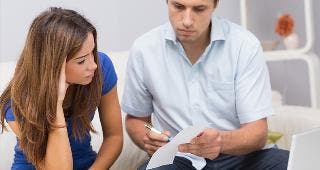 Worried couple paying bills online in living room © wavebreakmedia/Shutterstock.com