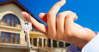Key on finger in front of house © Gabi Moisa / Fotolia.com