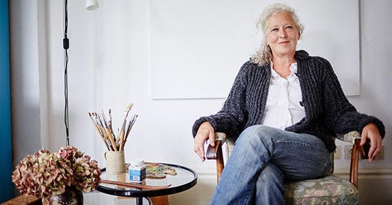Older woman sitting in chair by small table