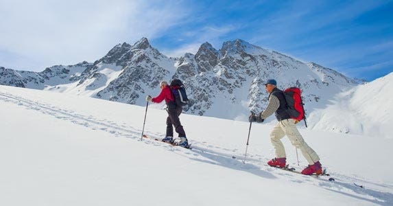 Two hikers climbing a mountain covered in snow
