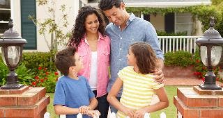 Happy family in house's front yard © Monkey Business Images/Shutterstock.com