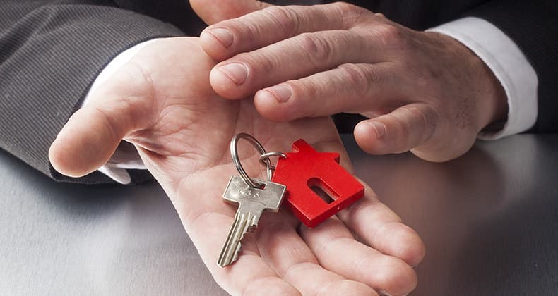 Businessman hands holding key with house keychain © STUDIO GRAND OUEST/Shutterstock.com