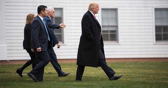 Experts give 50-50 odds Trump will face recession Donald Trump, Mike Pence and staff walking | The Washington Post/Getty Images
