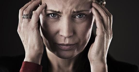 Which should I file first: Divorce or bankruptcy? Woman holding her temples, looking in pain | Caiaimage/Chris Ryan/Getty Images