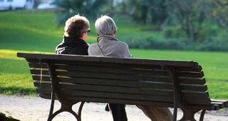 Couple sitting on bench in the park © auremar/Shutterstock.com