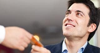 Man handing credit card to waiter © Minerva Studio/Shutterstock.com