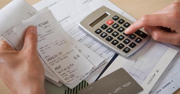 7 simple ways to improve your credit score Smartphone app calculating receipts | Chemistry/Getty Images