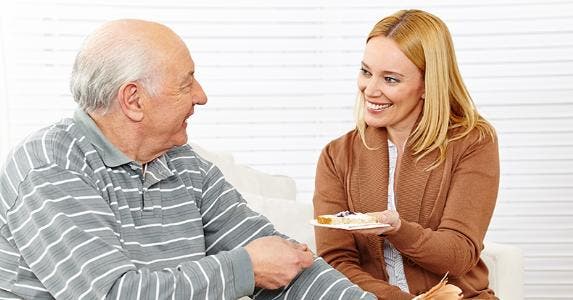 Senior man eating breakfast with assisted living home employee © Robert Kneschke/Shutterstock.com