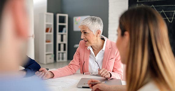 Woman talking to people at a table