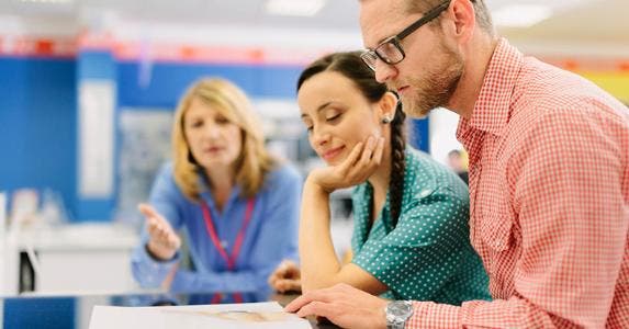 4 options to consider before buying an extended warranty Salesperson explaining terms on document to couple customers © iStock