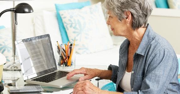 Mature woman working on finances with computer © iStock